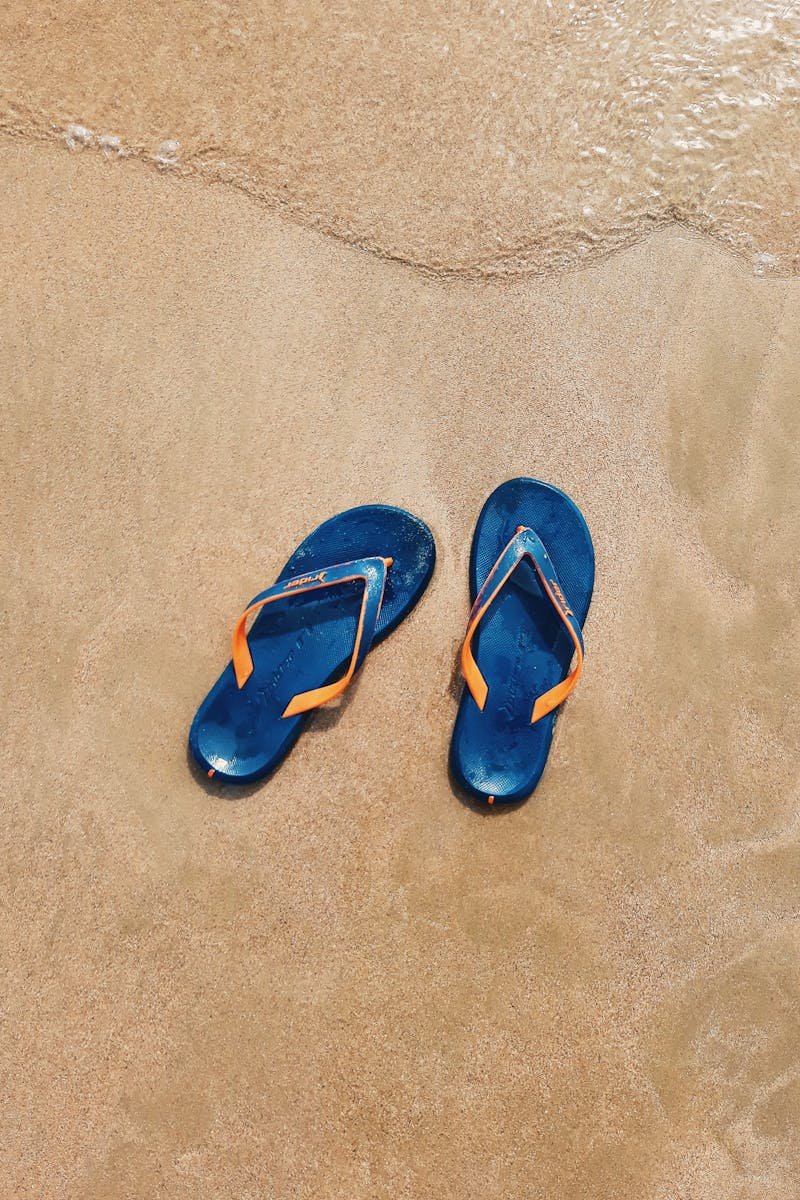 Par de sandalias azules en la playa